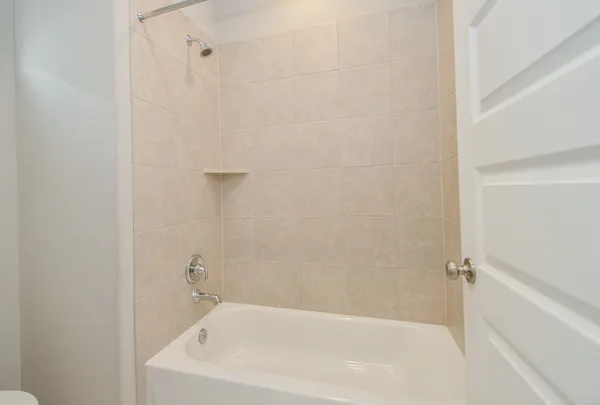 a white bath tub sitting next to a white sink and vanity