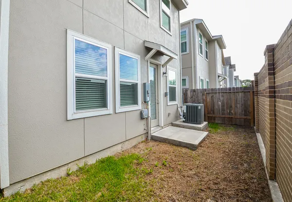 a view of a house with backyard and wooden fence