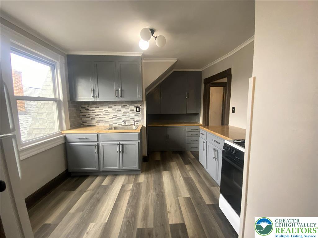 436 Wheeler Avenue, Unit 3 Scranton, PA 18510 - Photo 4 of 8 a kitchen with a refrigerator and white cabinets