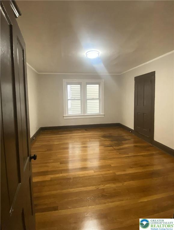 436 Wheeler Avenue, Unit 3 Scranton, PA 18510 - Photo 7 of 8 an empty room with wooden floor and windows with curtains