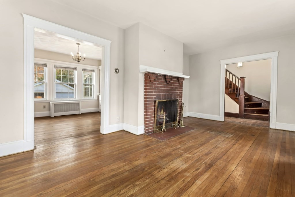 78 Ashcroft Road Medford, MA 02155 - Photo 6 of 34 an empty room with wooden floor and a fireplace
