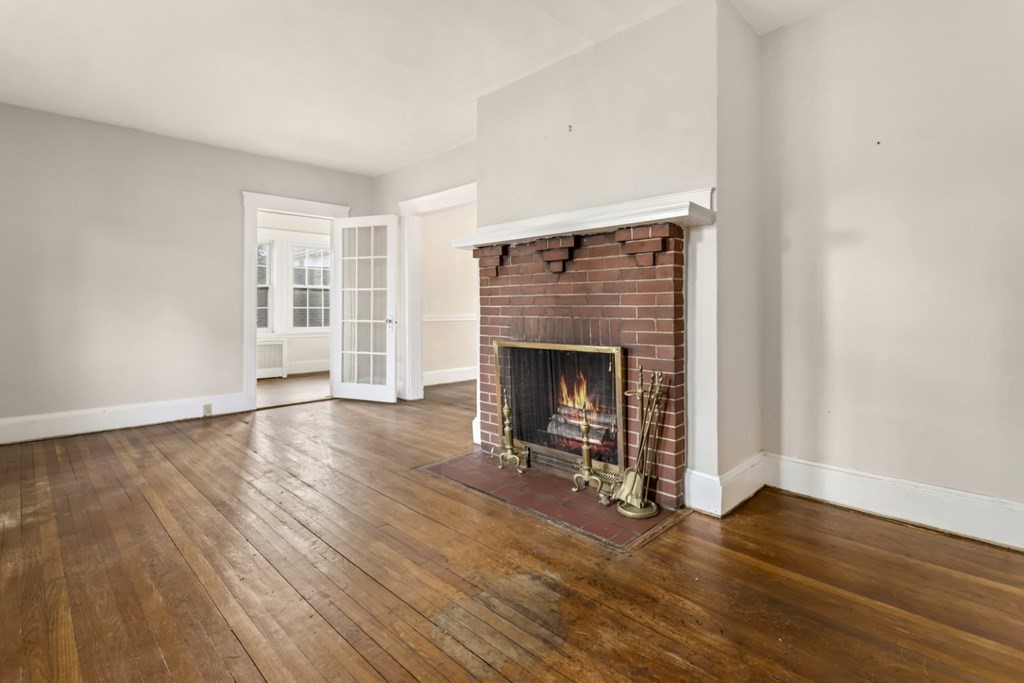 78 Ashcroft Road Medford, MA 02155 - Photo 7 of 34 an empty room with wooden floor and fireplace
