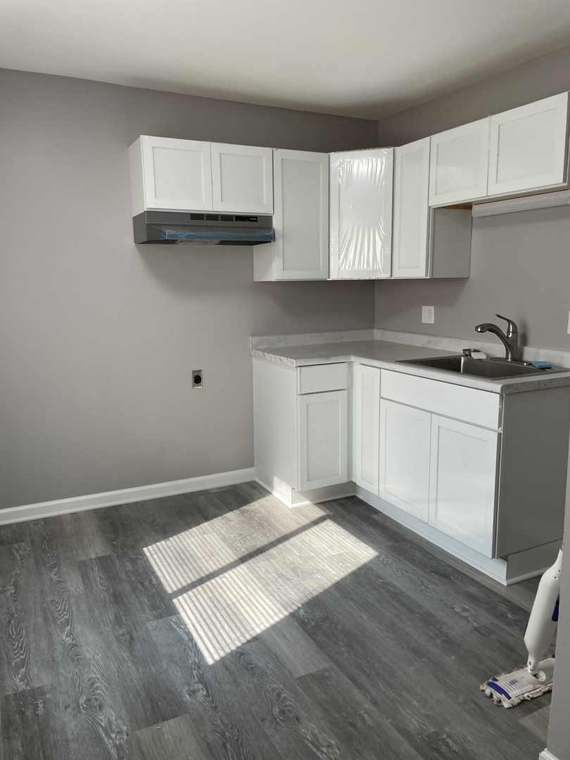 1389 Monomoy Street, Unit B2 Aurora, IL 60506 - Photo 3 of 6 a kitchen with granite countertop a sink cabinets and wooden floor