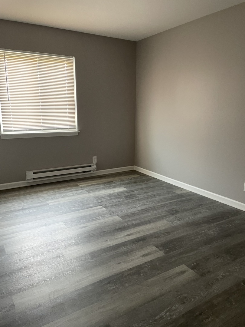 1389 Monomoy Street, Unit B2 Aurora, IL 60506 - Photo 5 of 6 an empty room with wooden floor and windows