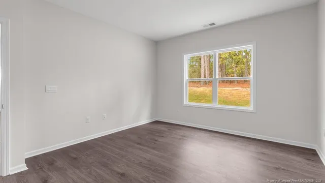 an empty room with wooden floor and a window