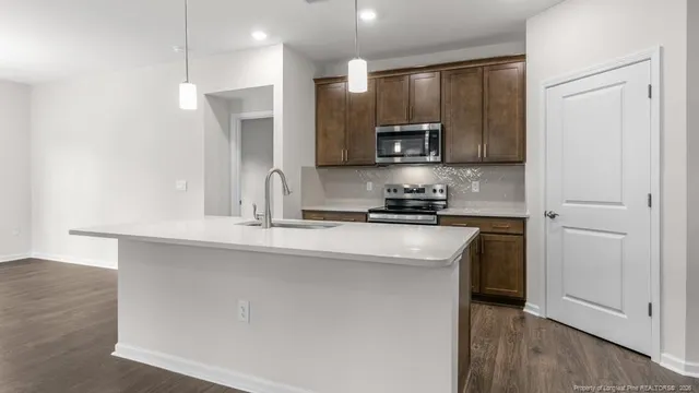 a kitchen with stainless steel appliances granite countertop a sink a stove and a refrigerator