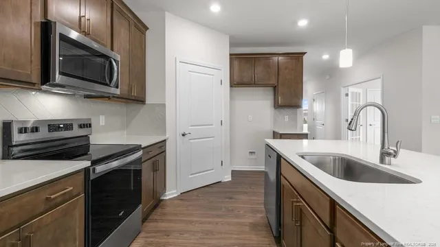 a kitchen with stainless steel appliances granite countertop a sink and a microwave