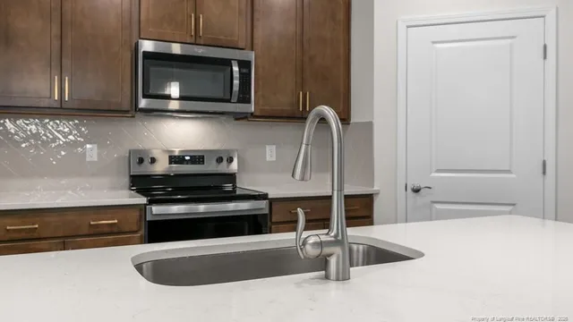 a kitchen with stainless steel appliances granite countertop a stove and a microwave with granite countertops