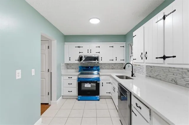 a kitchen with stainless steel appliances a sink stove and cabinets