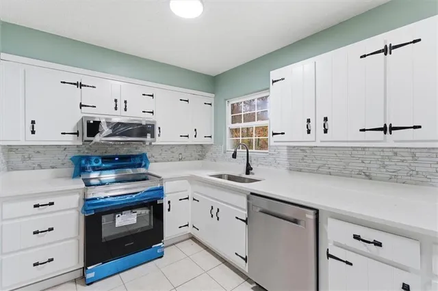 a kitchen with granite countertop white cabinets and white appliances