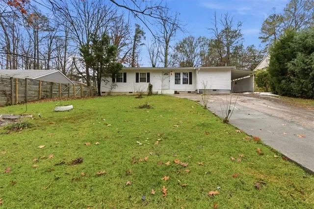 a front view of a house with a yard and trees