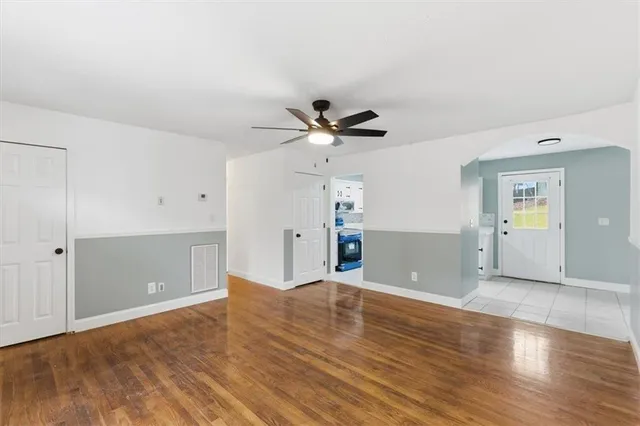 a view of an empty room with window and wooden floor