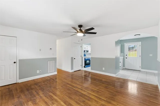 a view of an empty room with window and wooden floor