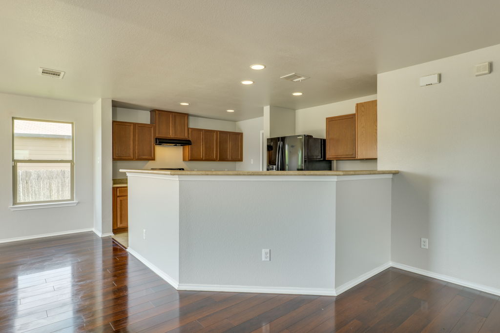 210 Cushman Drive Kyle, TX 78640 - Photo 8 of 21 Open-concept layout featuring rich wood-finish flooring, recessed lighting, and a breakfast bar