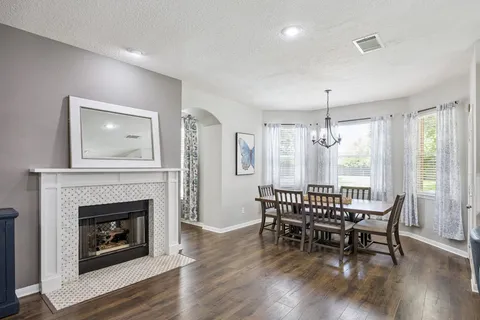 a dining room with furniture window and wooden floor