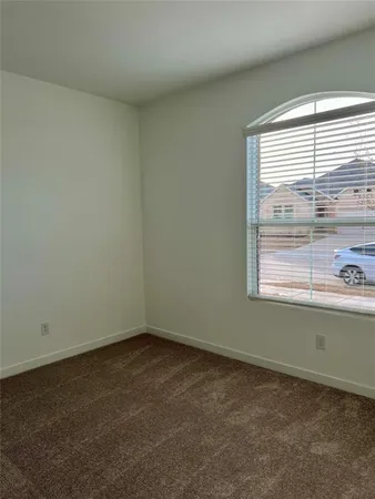 a view of a hallway with wooden floor and a window