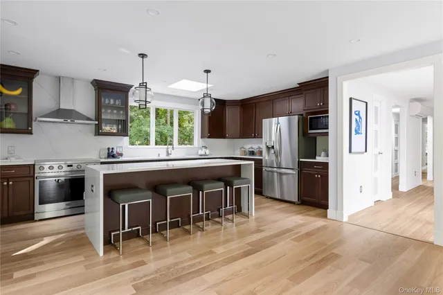 a kitchen with stainless steel appliances a sink cabinets and wooden floor