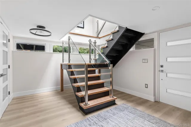 a view of a hallway with two couches and a large window with wooden floor