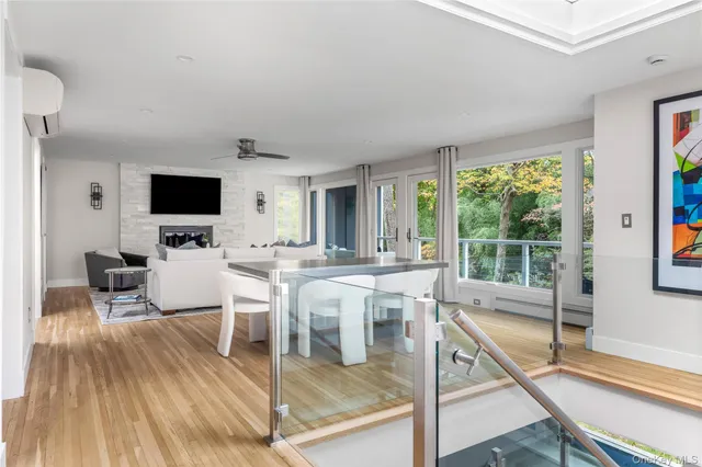 a living room with furniture a flat screen tv and a floor to ceiling window