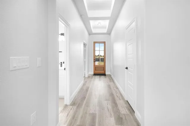 a view of a hallway with wooden floor