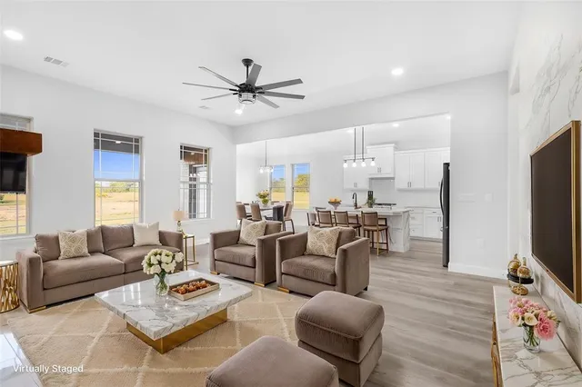 a living room with furniture a flat screen tv and a window