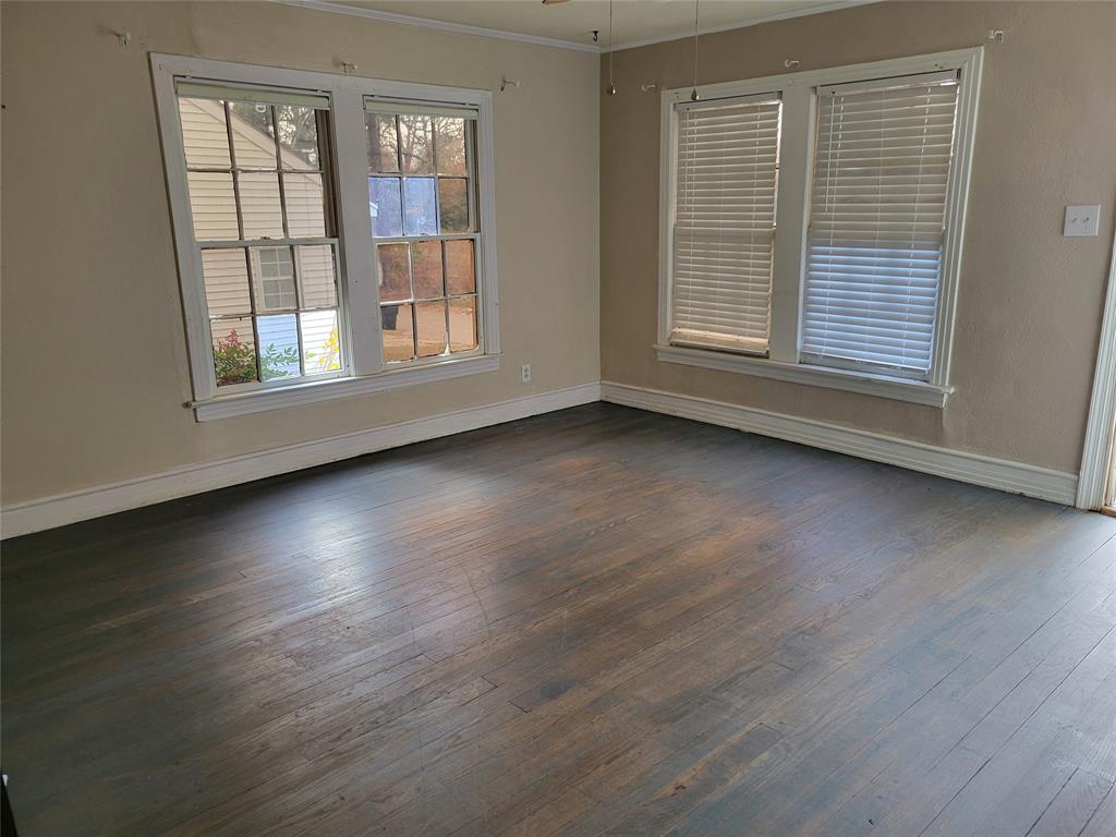 211 Wichita Street Shreveport, LA 71101 - Photo 2 of 10 Spare room with dark wood-style floors and ornamental molding