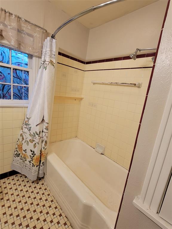 211 Wichita Street Shreveport, LA 71101 - Photo 5 of 10 Bathroom featuring shower / tub combo with curtain and tile patterned floors