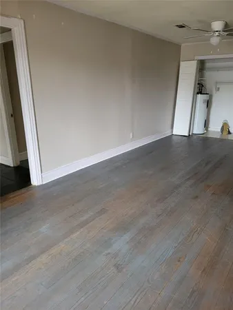a view of empty room with wooden floor
