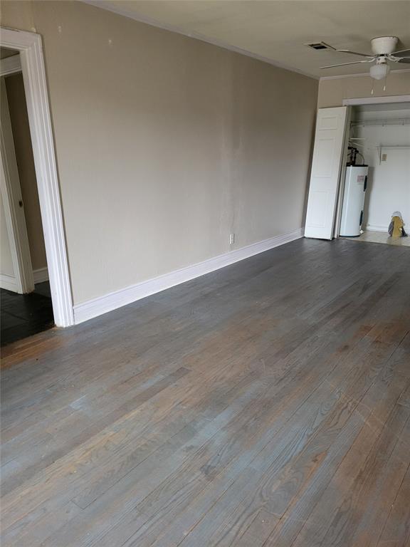 211 Wichita Street Shreveport, LA 71101 - Photo 8 of 10 Unfurnished living room featuring dark wood-style floors, electric water heater, and ceiling fan