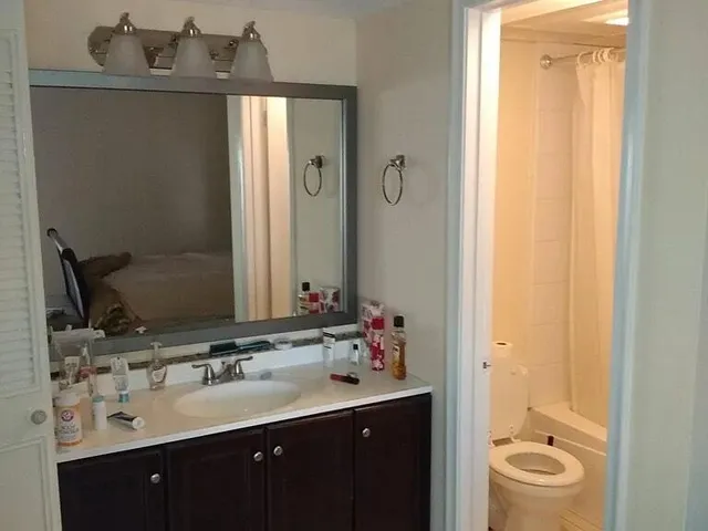 a bathroom with a double vanity sink and mirror with shower