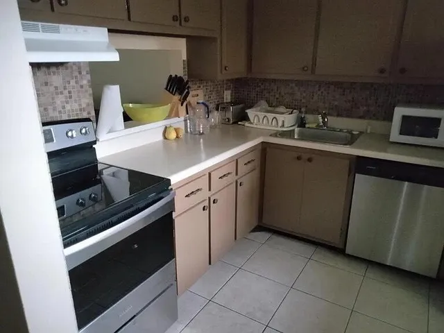a kitchen with a sink stove and cabinets