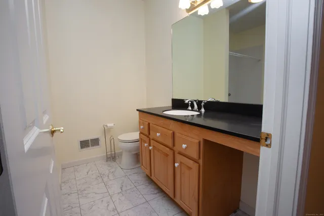 a bathroom with a sink a toilet and a mirror