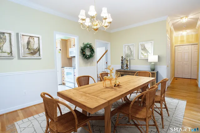 a dining room with furniture a chandelier and wooden floor