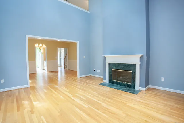 a view of empty room with a fireplace and wooden floor