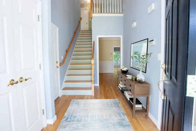 a view of a hallway with wooden floor and staircase