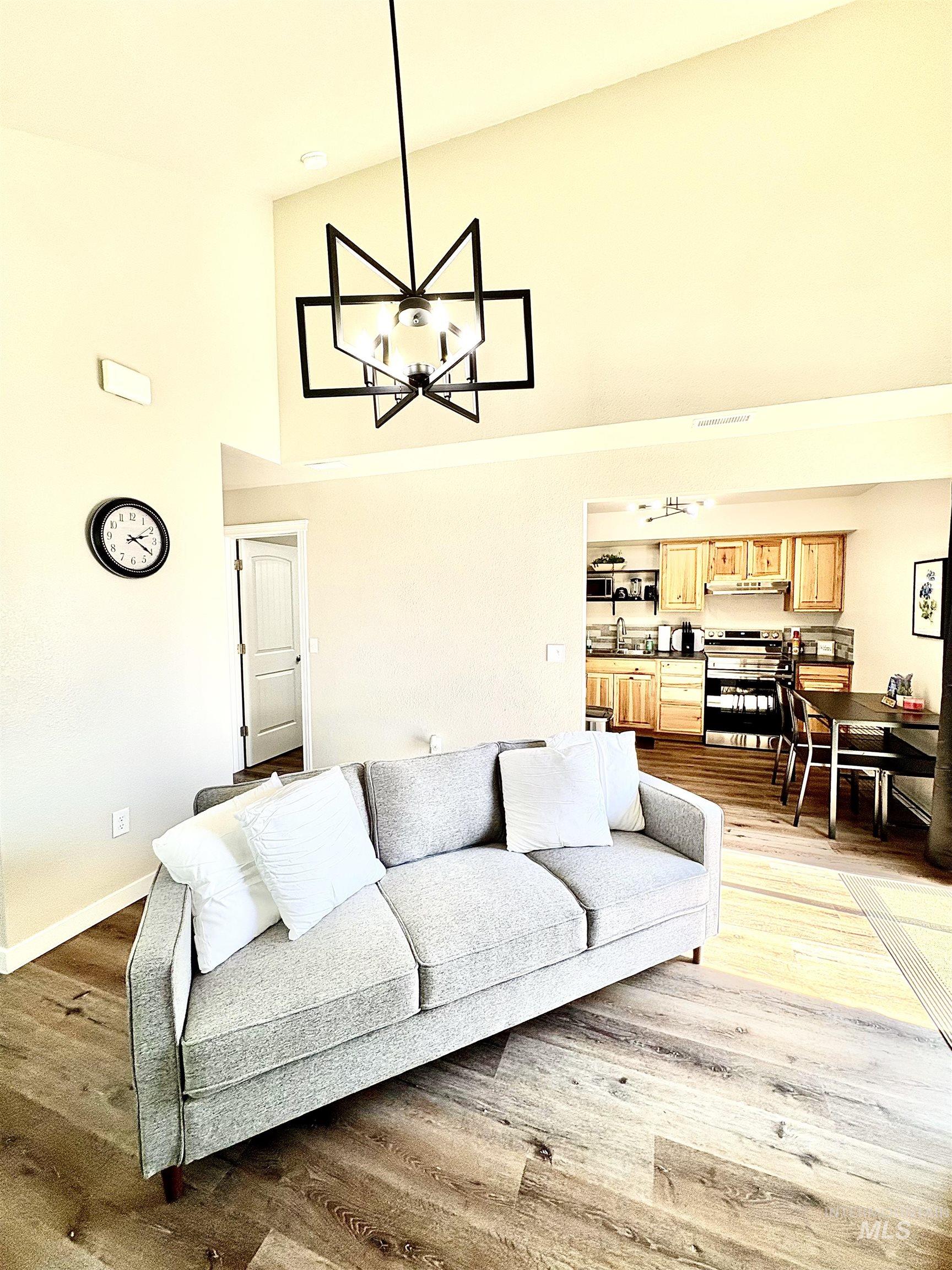 4802-4804 Maid Jessica Street Caldwell, ID 83607 - Photo 26 of 31 Living room with high vaulted ceiling, a chandelier, and light wood finished floors
