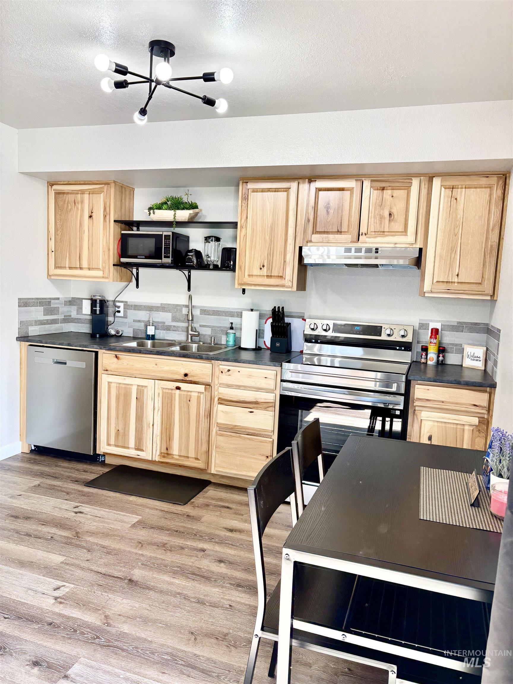 4802-4804 Maid Jessica Street Caldwell, ID 83607 - Photo 28 of 31 Kitchen with dark countertops, light brown cabinets, stainless steel appliances, and a textured ceiling