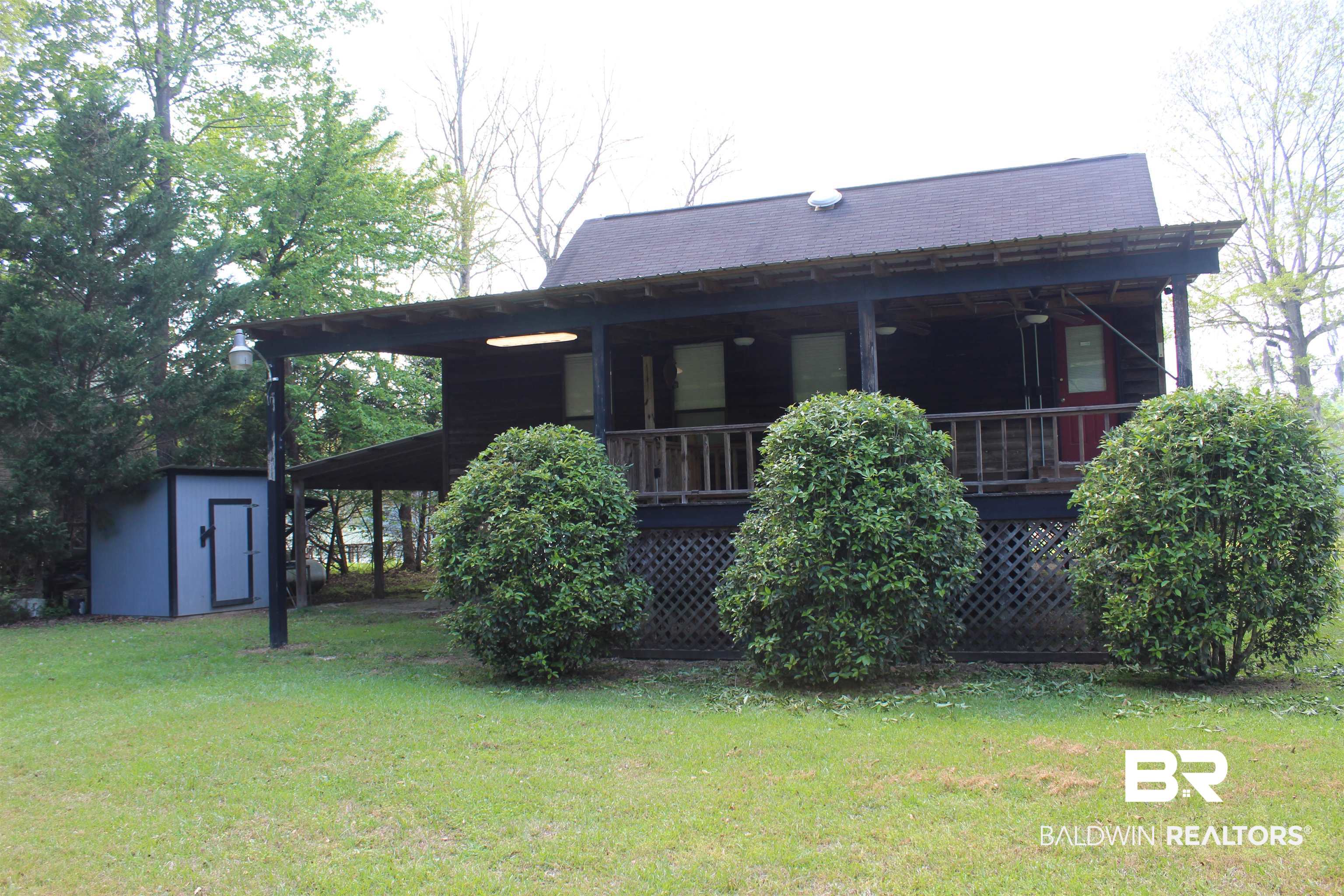 6447 Henderson Road Lowndesboro, AL 36752 - Photo 3 of 22 Back of property featuring a lawn, a shed, covered porch, and an attached carport