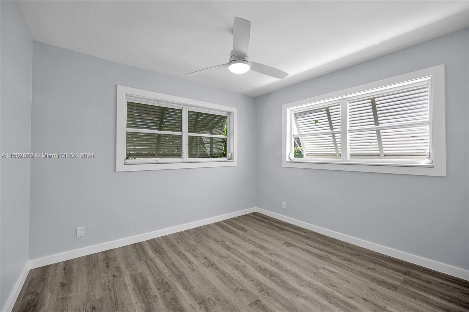 2598 Lone Pine Road Palm Beach Gardens, FL 33410 - Photo 12 of 29 a view of empty room with wooden floor and fan