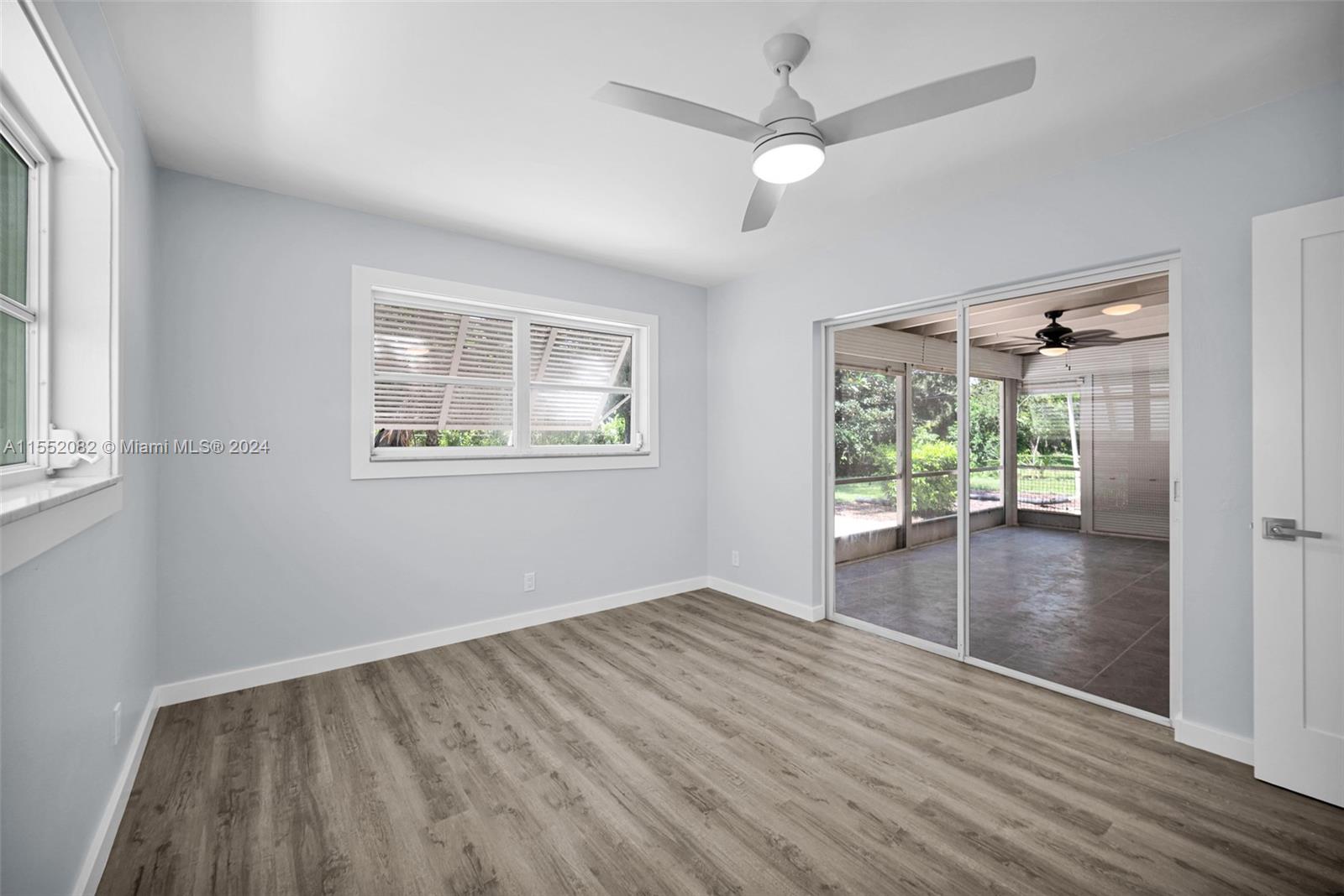 2598 Lone Pine Road Palm Beach Gardens, FL 33410 - Photo 15 of 29 an empty room with wooden floor fan and windows