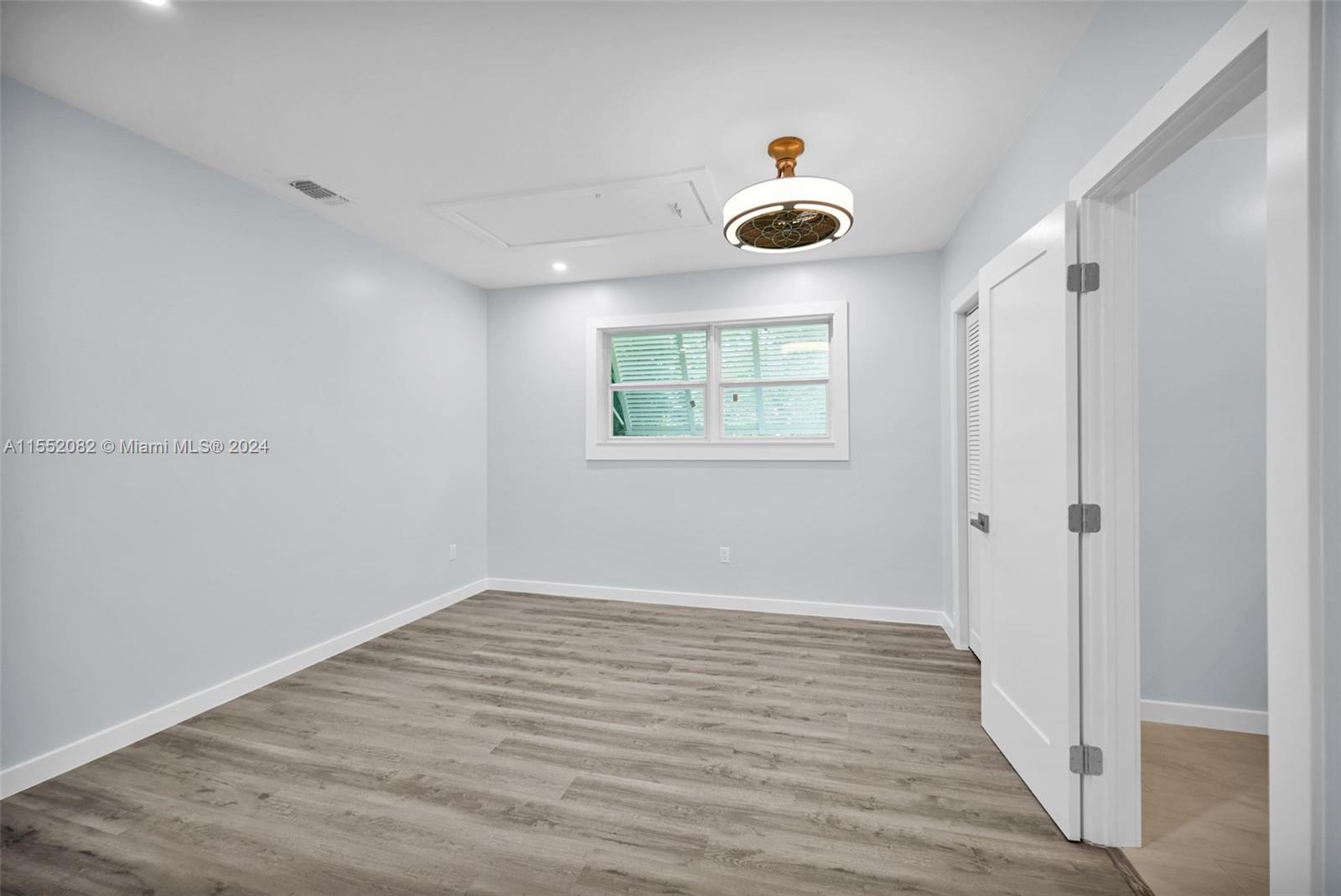 2598 Lone Pine Road Palm Beach Gardens, FL 33410 - Photo 21 of 29 a view of an empty room with a window and wooden floor