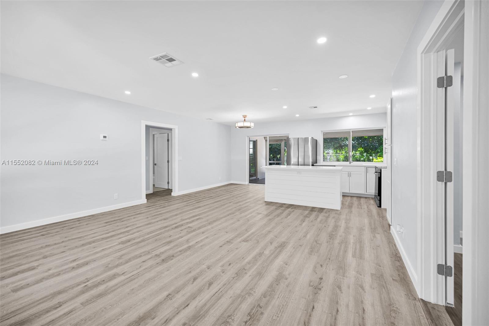2598 Lone Pine Road Palm Beach Gardens, FL 33410 - Photo 3 of 29 a view of a big room with wooden floor and windows