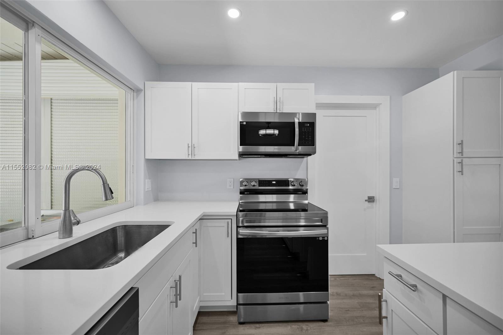 2598 Lone Pine Road Palm Beach Gardens, FL 33410 - Photo 4 of 29 a kitchen with a sink a stove and cabinets
