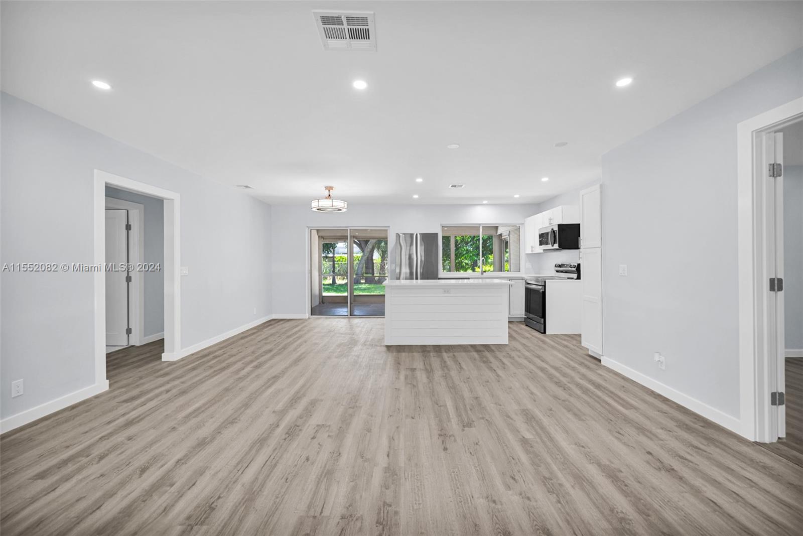 2598 Lone Pine Road Palm Beach Gardens, FL 33410 - Photo 10 of 29 a view of a room with wooden floor and windows