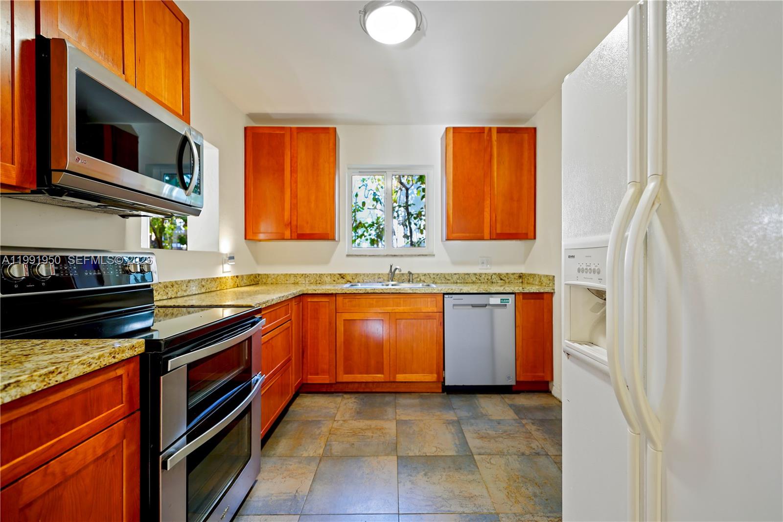 720 Northeast 75th Street Miami, FL 33138 - Photo 15 of 36 a kitchen with stainless steel appliances granite countertop a stove a sink and a microwave