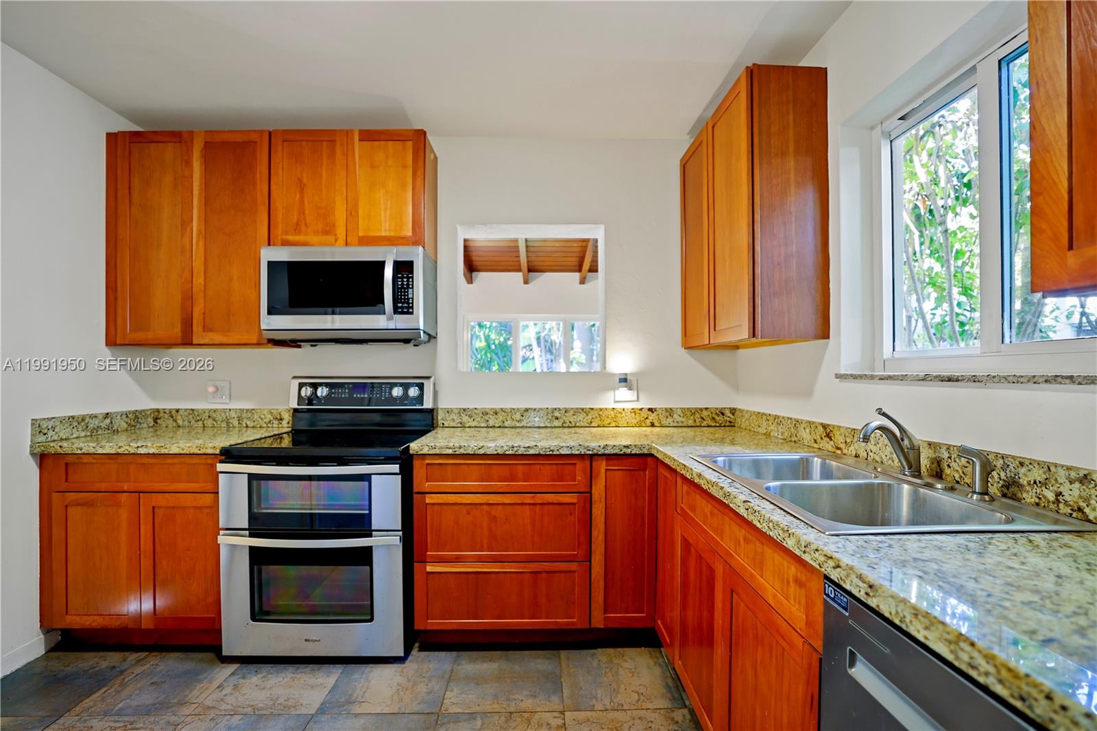 720 Northeast 75th Street Miami, FL 33138 - Photo 16 of 36 a kitchen with stainless steel appliances granite countertop a sink stove and microwave