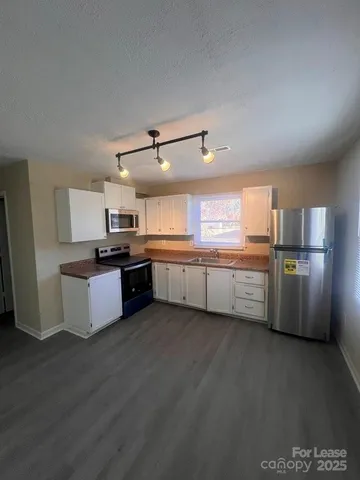 a large kitchen with stainless steel appliances and a refrigerator