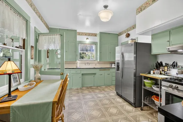 a room with a stove a sink and a window