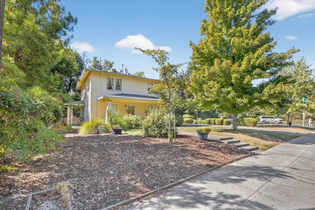 a front view of a house with garden and sitting area