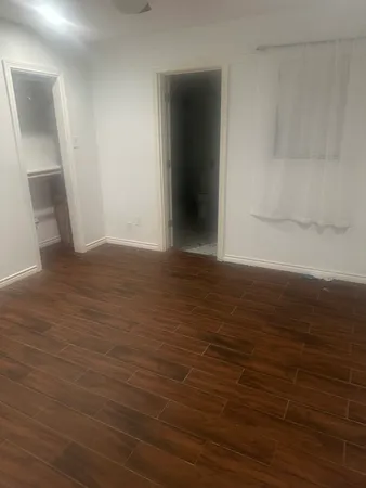 a view of a room with wooden floor